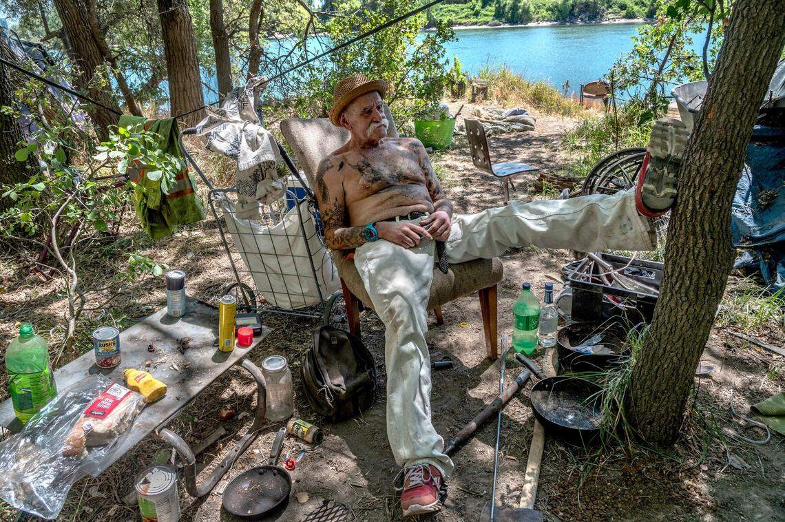 Carlos, 67, relaxes under the trees in June at the camp where he says he’s lived for over ten years. “We know we are not supposed to be here, but we are homeless, and if I had someplace else to go, I’d go there,” he said.