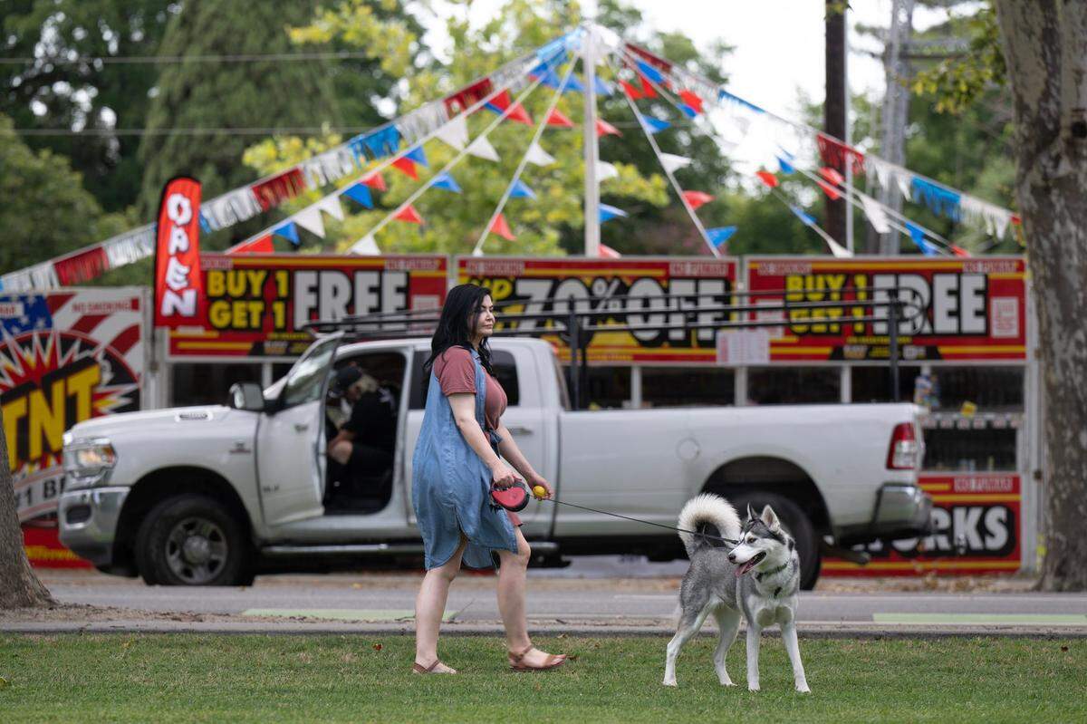 Shauntel Sarionder walks her dog Bella in front of a fireworks stand at Esparto Community Park on Thursday, July 3, 2025. “It’s a quiet community, everybody knows each other,” said Sarionder, who has lived in Esparto for 10 years.