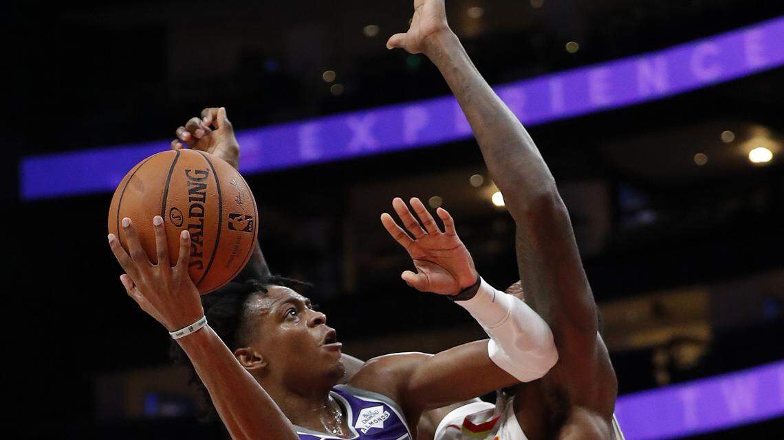 Kings guard De’Aaron Fox drives into Atlanta Hawks center Dewayne Dedmon on Thursday in Atlanta. Fox set career highs in scoring (31), rebounds (10) and assists (15) in earning his first NBA triple-double as the Kings won 146-115.