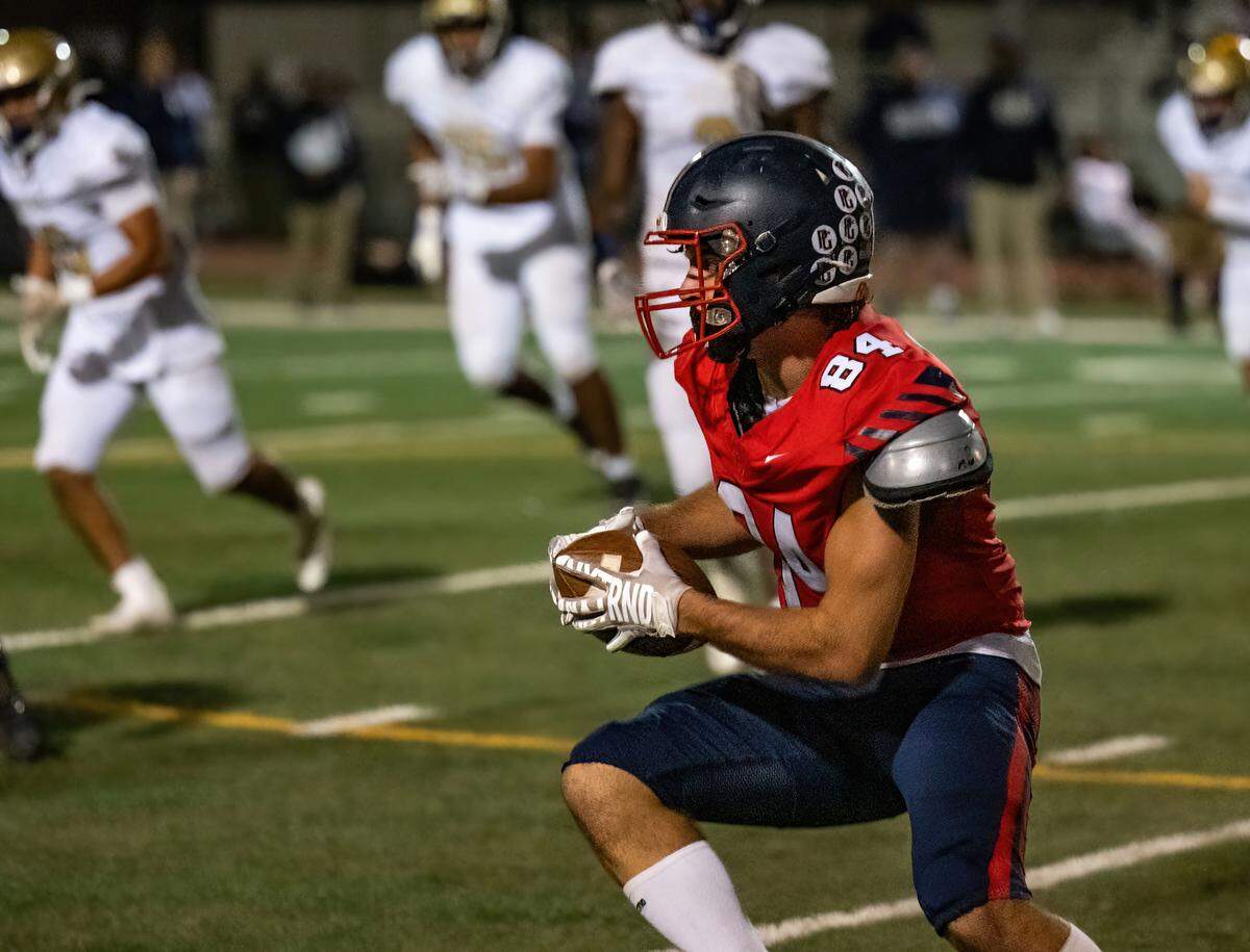 Pleasant Grove Eagles outside linebacker Zachary Barbieri (84) pulls down an interception against the Elk Grove Thundering Herd in the fourth quarter on Friday at Sheldon High School.