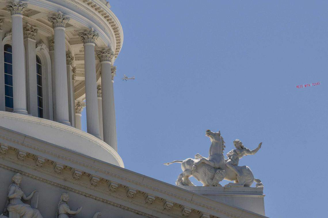 A small plane flies a "mess with Texas" banner in the sky above the California Capitol in Sacramento on Monday. The sign references the ongoing redistricting debate in Texas and whether or not states with democratic control should also redistrict their congressional maps.