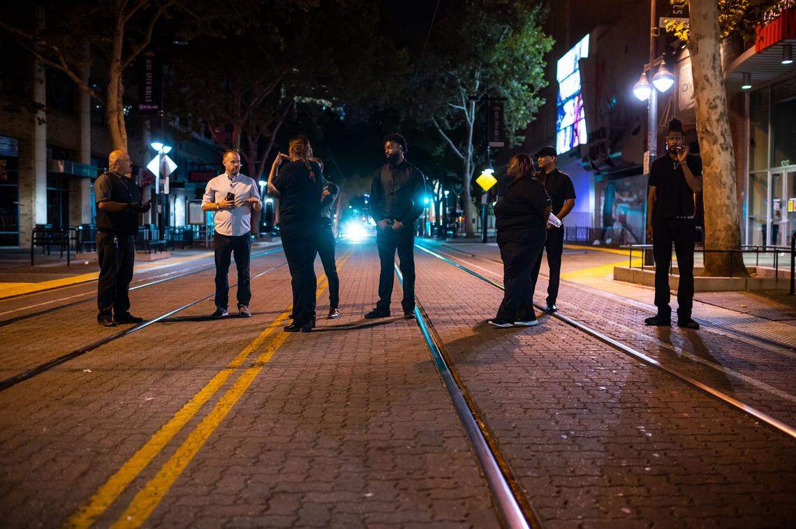 Sergio, left, who runs security at Dive Bar and District 30 on the 1000 block of K Street, works with staff to facilitate a smooth closing last month as bars and nightclubs close up and people leave the area or mingle in downtown Sacramento. He and his team usher patrons away from the establishments’ entryways as police keep a presence nearby. Sergio said he was working the night six people were killed and several others injured nearby during a mass-casualty gun battle on the street following an altercation at closing time, April 3.