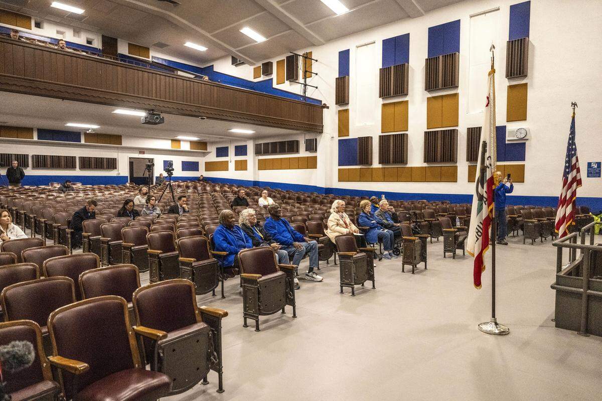 Members of the Grant Union High School Alumni Association listen to remarks during the unveiling of the school’s renovated auditorium on Monday.