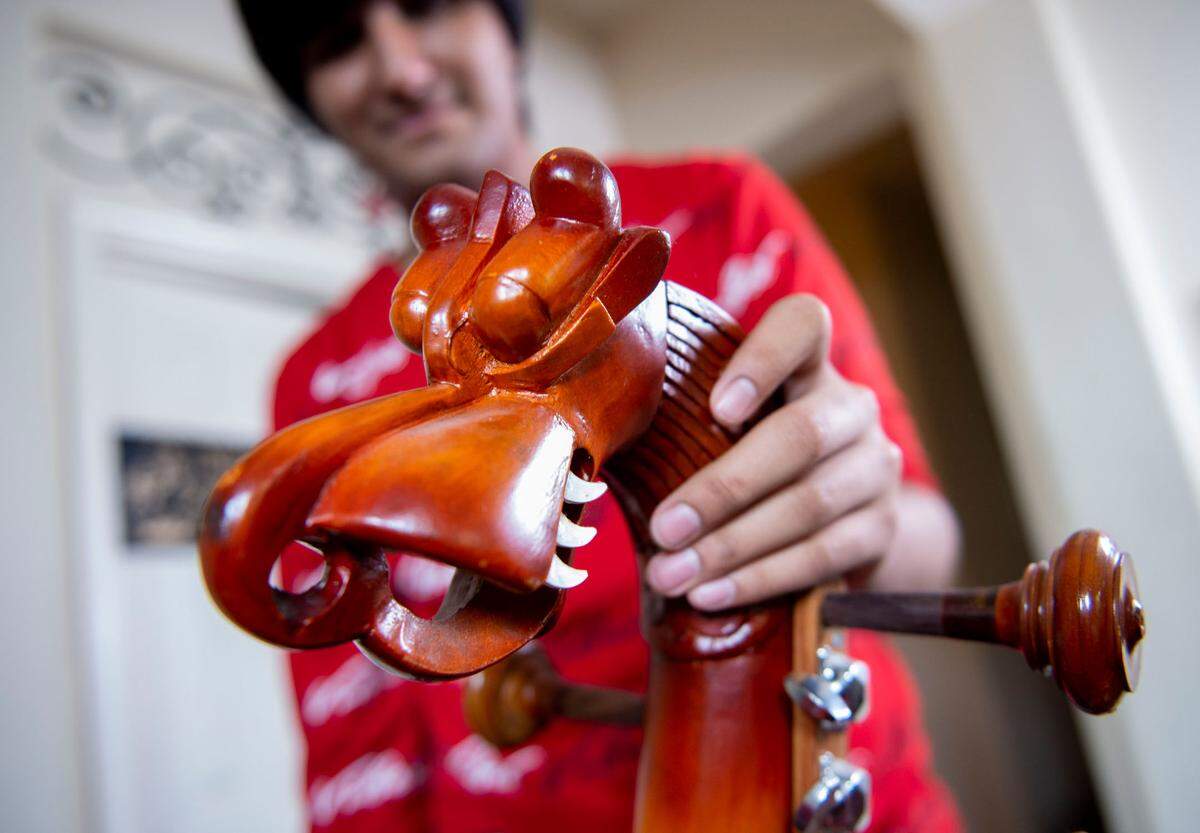 Neil Nayyar shows a dragon carving on the neck of his Saraswati veena from India.
