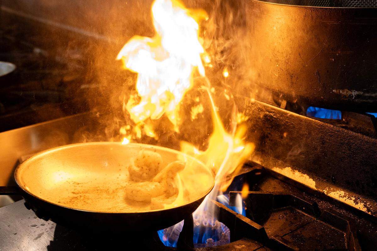 Shrimp sizzles in the kitchen at Ippolito’s Trattoria in Rosemont earlier this month.