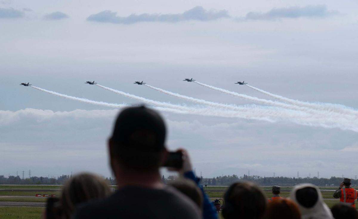 Spectators watch the U.S. Navy Blue Angels perform at the California Capital Airshow at Mather Airport on Saturday, March 22, 2025.
