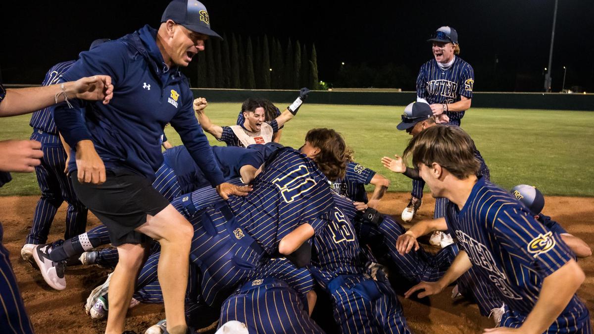 Sutter Huskies catcher Landon Sable (3), kneeling and raising his arms at left, cheers with his teammates piled up after defeating Bradshaw Christian 4-3 in the 13th inning for the CIF Sac-Joaquin Section Division V high school baseball title Tuesday, May 23, 2023, at Sacramento City College.