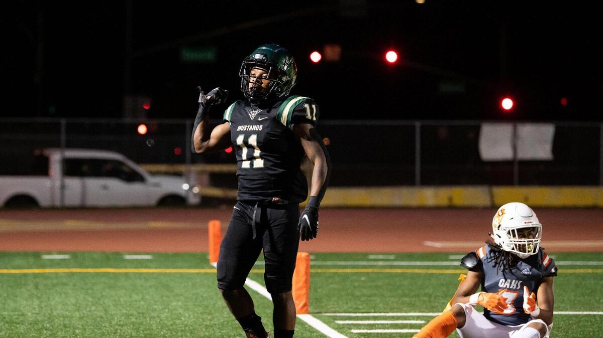 Monterey Trail’s Jamauri Jackson, left, tosses the ball after intercepting a pass intended for Cosumnes Oaks’ Gregory Bradley, right, during the fourth quarter of the high school football game Friday, April 2, 2021, at Monterey Trail High School in Elk Grove. Monterey Trail beat Cosumnes Oaks 57-21.
