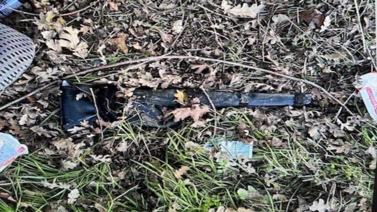An elongated black object lies on the ground near where deputies confronted Marvin Morales after his vehicle crashed along Interstate 5 on Dec. 2, 2025. Authorities said deputies believed Morales was pointing what appeared to be a rifle before they opened fire on the ex-deputy.