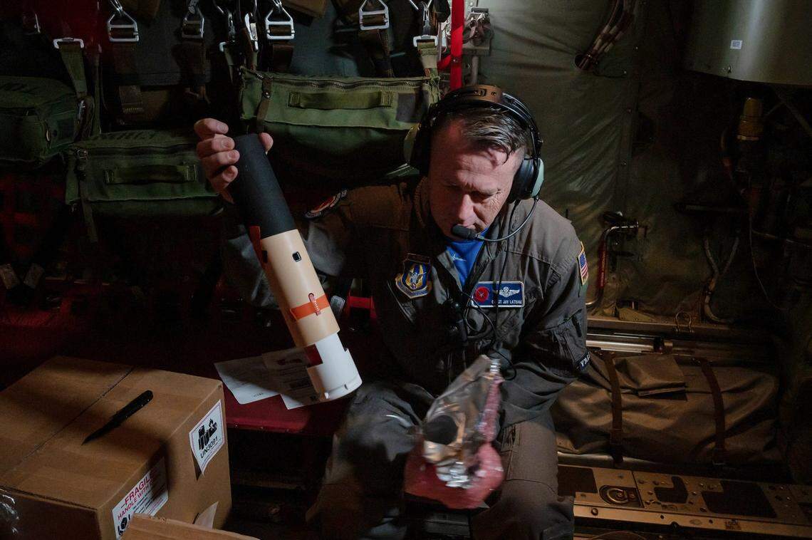 Chief Master Sgt. Jay Latham, loadmaster for the U.S. Air Force Reserve 53rd Weather Reconnaissance Squadron “Hurricane Hunters,” takes a dropsonde out of its packaging to ready it for a mission in January 2023 aboard a WC-130J Super Hercules over the Pacific Ocean. The dropsonde collects data about wind speeds, temperatures, pressure and humidity from the storm before it makes landfall.