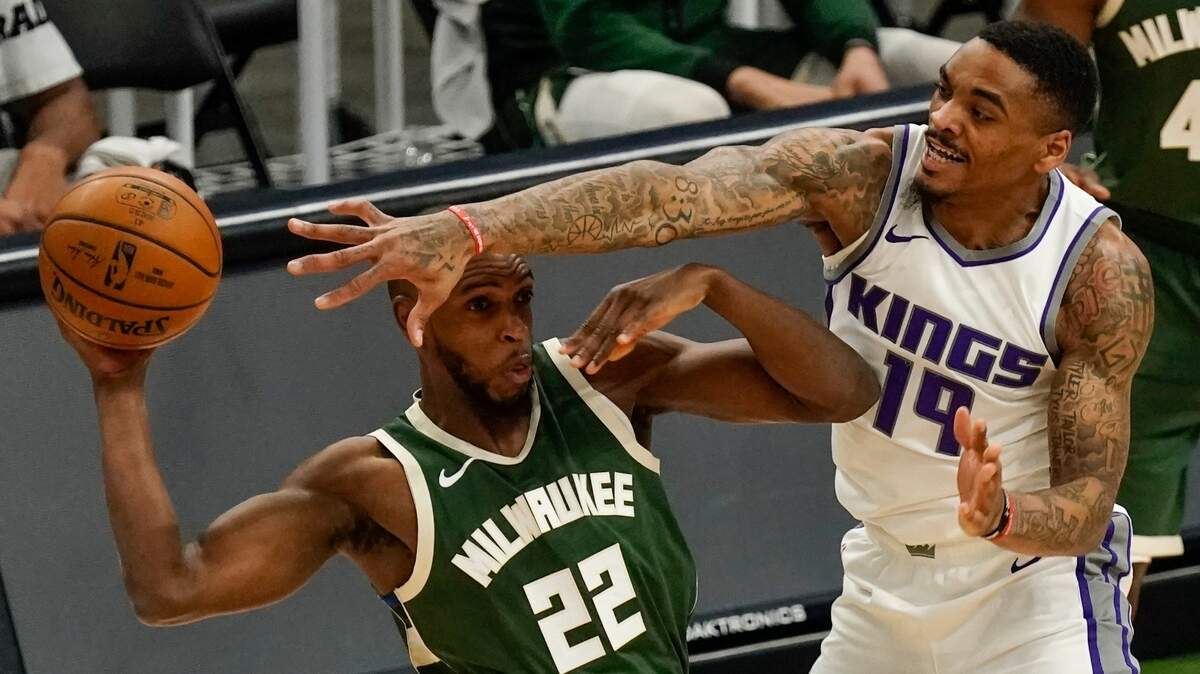 Milwaukee Bucks’ Khris Middleton looks to pass around Sacramento Kings’ DaQuan Jeffries during the first half of an NBA basketball game Sunday, Feb. 21, 2021, in Milwaukee. (AP Photo/Morry Gash)