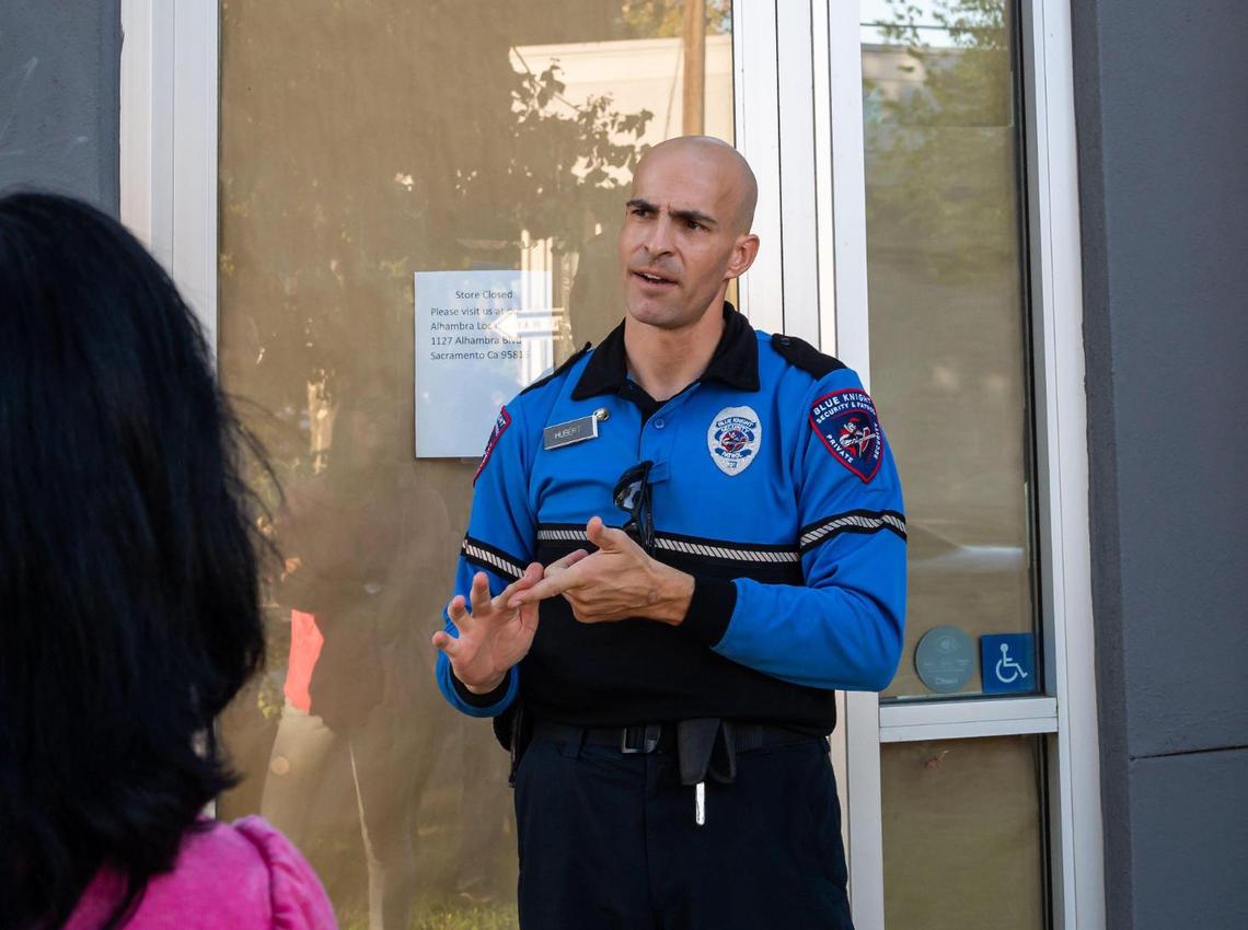 Security guard Hubert, no first name given, with Blue Knight Security & Patrol, talks with area residents in front of the closed Jamba Juice location at 15th Street and Broadway earlier this month. “Violent crime is not a problem here, (it’s) drugs,” he said later. He said the security company provides contract security service for businesses with the Greater Broadway Partnership.