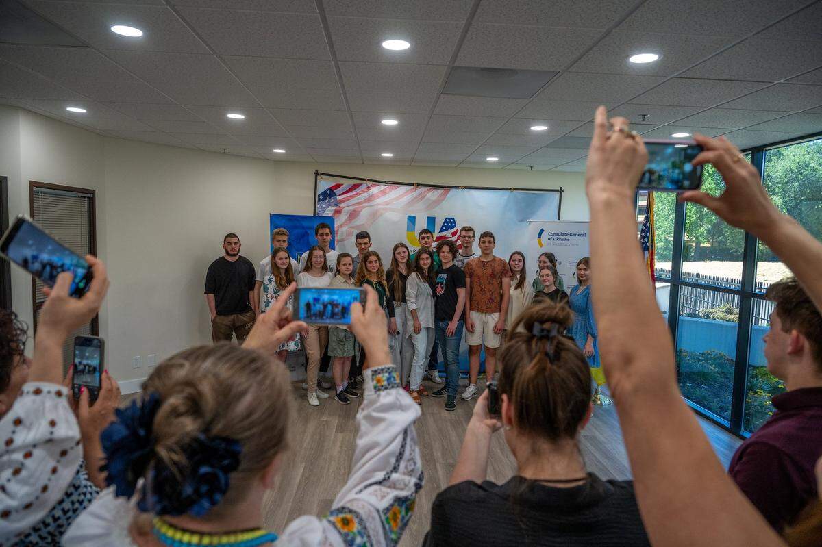 Ukrainian refugee high school graduates have their pictures taken by parents after they completed their National Multi-subject Test at the Ukrainian American House in Rancho Cordova on Tuesday.