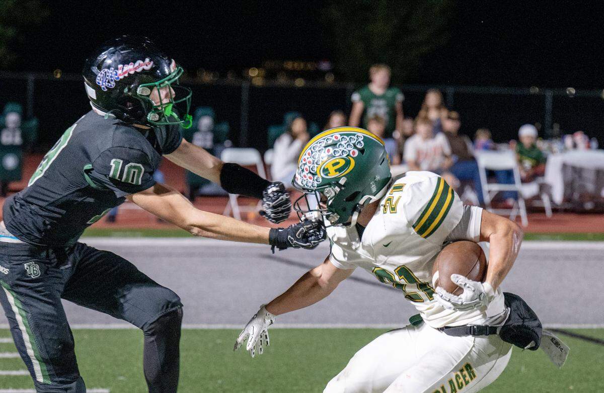Placer Hillmen running back Danny Sanchez-Harlow (21) is tackled by the Twelve Bridges Raging Rhinos' Dylan Amos (10) after a run in the second half Friday, Oct. 10, 2025, in Roseville.