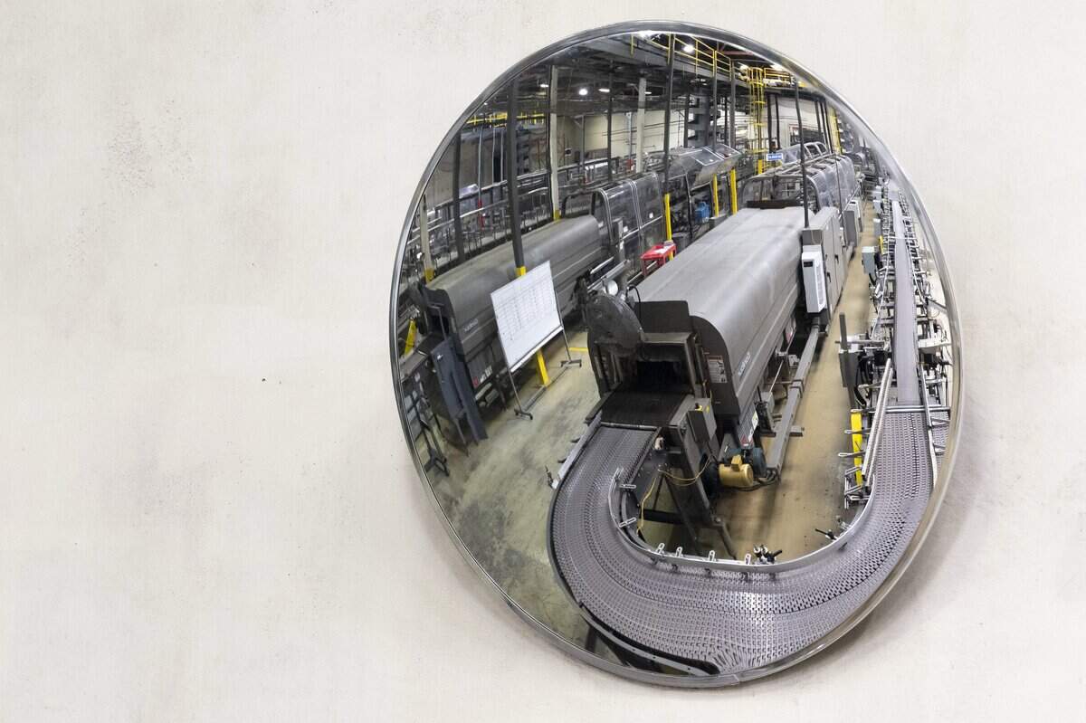 One of the production lines in the Redwood Beverage Group plant in West Sacramento is reflected in a mirror on the plant wall on Thursday.