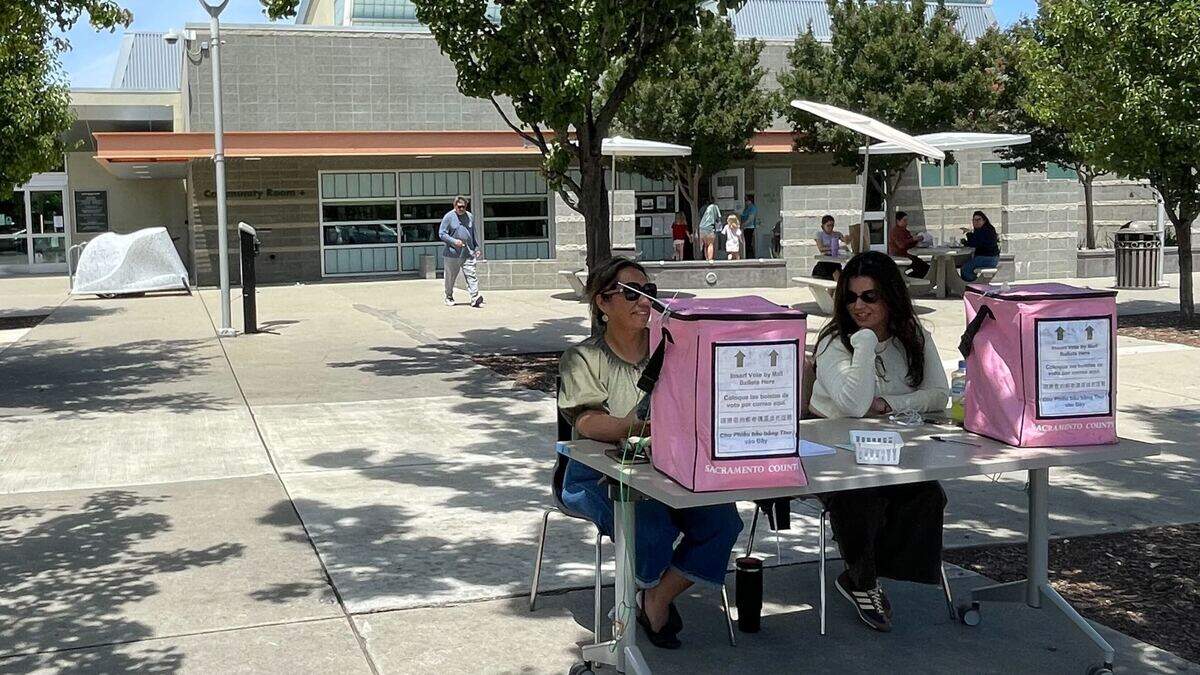 Primary election workers monitor the curbside ballot drop-off at the North Natomas library, which neighbors American River, on Tuesday, June 2, 2026.