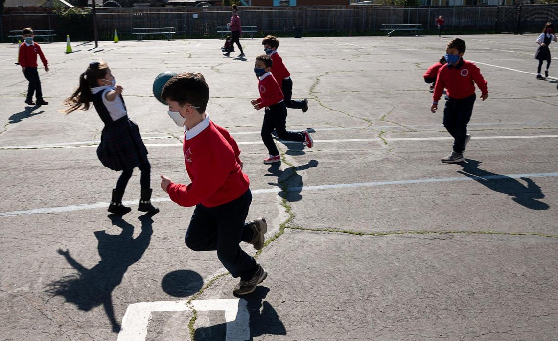 Joseph Markstein, 7, wears a face mask while playing with other students during recess at Saint Philomene School on Wednesday, Feb. 10, 2021, in Sacramento.