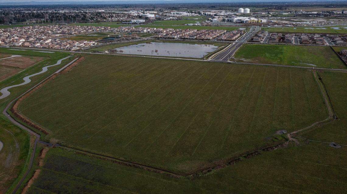 An aerial view shows the proposed Elk Grove site for the Sacramento Zoo in the foreground in December, with newly constructed Lotz Parkway crossing the middle of the image. New homes and the under construction Sky River Casino are visible in the distance. The zoo would be accessed from Highway 99 via Kammerer Road.