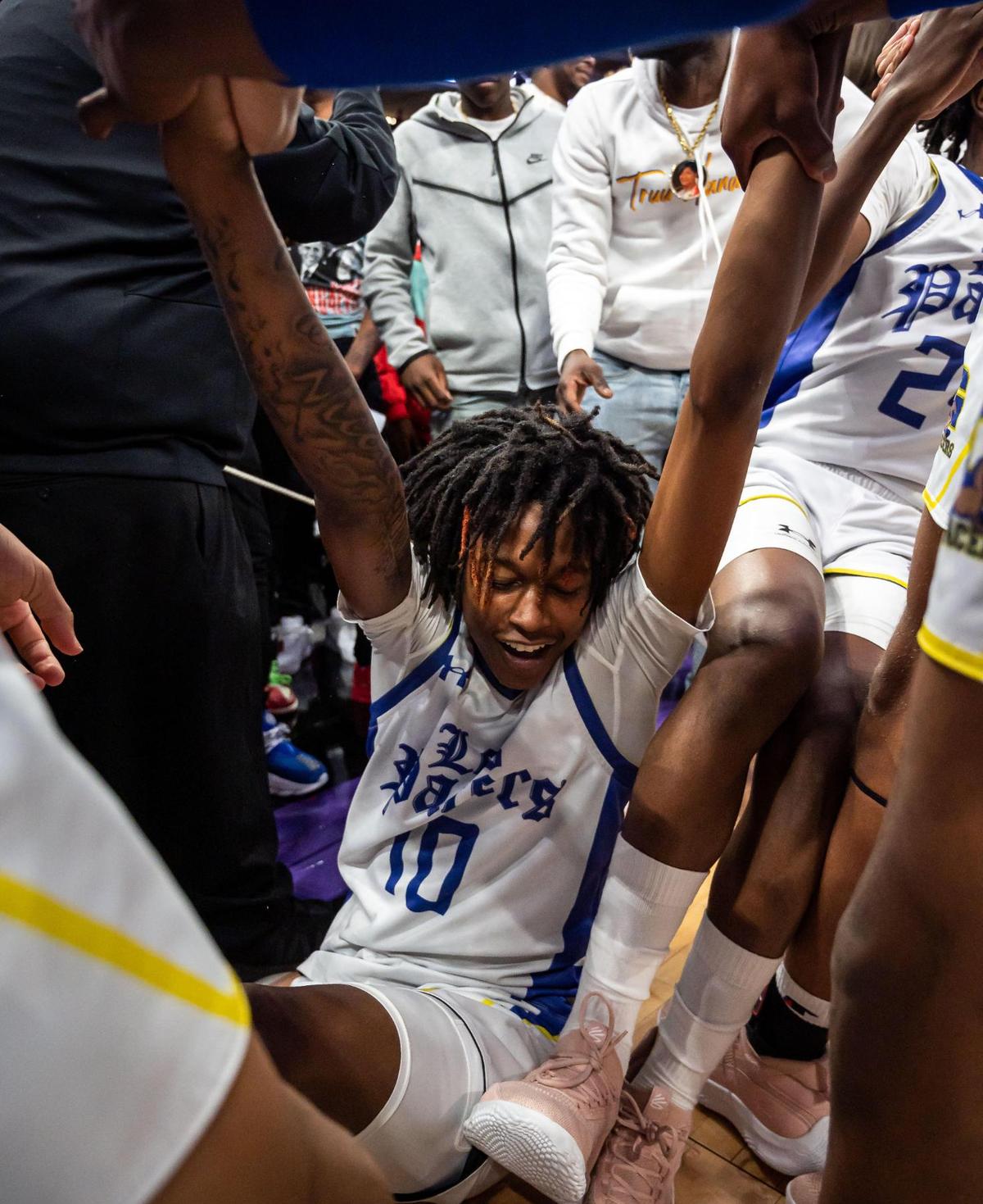Grant Pacers’ Rishod Brown (10) is lifted up from the ground after being surrounded by teammates at the conclusion of their 65-58 win over Granite Bay at the high school boys basketball Sac-Joaquin Section Division II championship game Friday, Feb. 25, 2022, at Golden 1 Center in Sacramento.