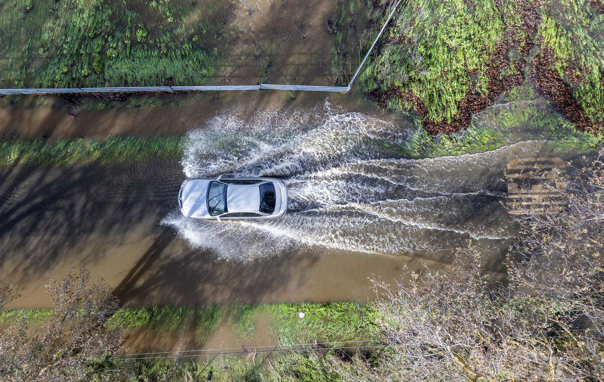 A motorist drives on the flooded Cherry Lane in Rio Linda on Friday. Heavy rains on Christmas Day brought flooding to the area from nearby Dry Creek. 