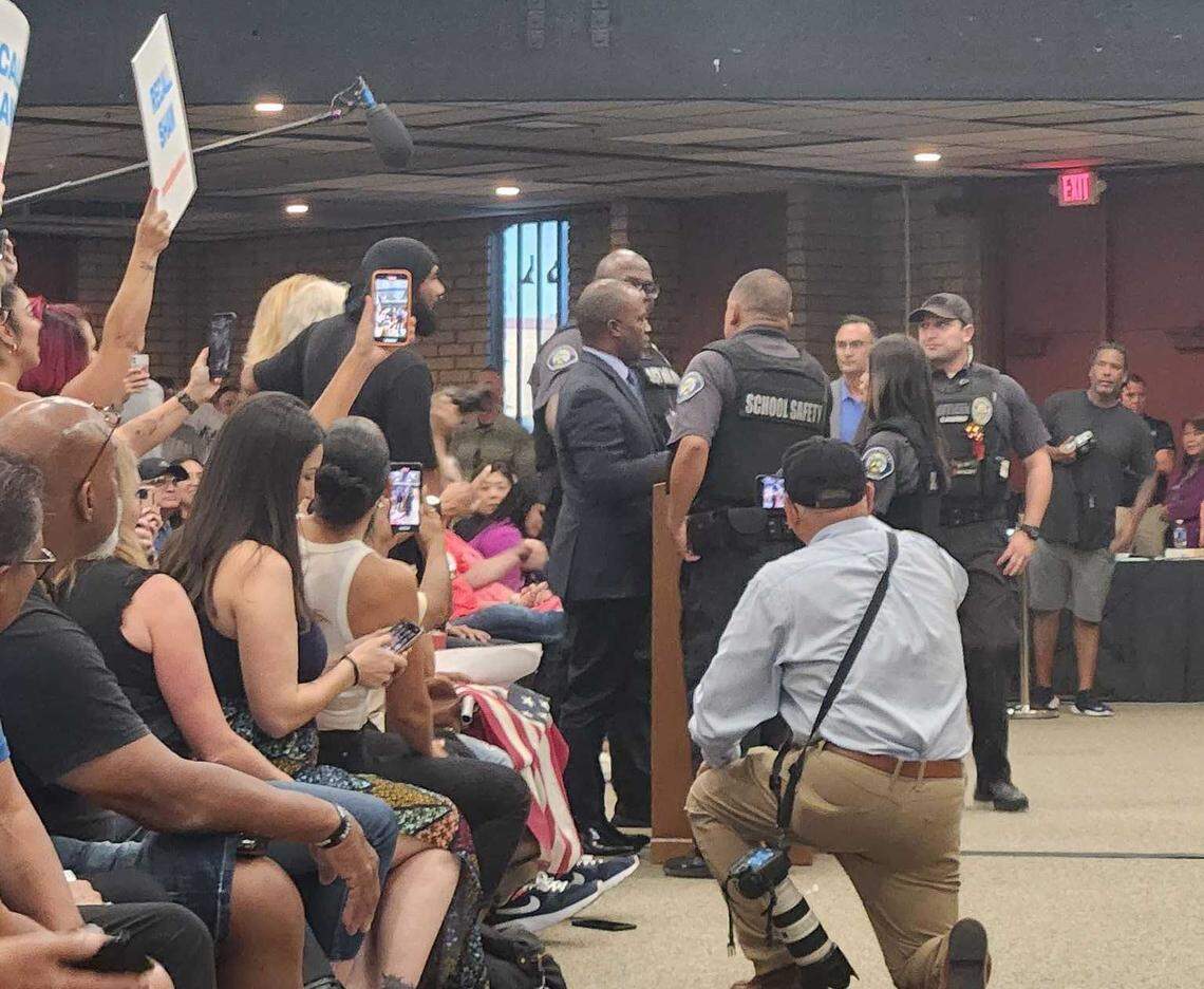 State Superintendent of Public Instruction Tony Thurmond is escorted out of the Chino Valley school board meeting Thursday, July 20, 2023, by security officers. Board President Sonja Shaw said he went over the one-minute time limit for speakers.