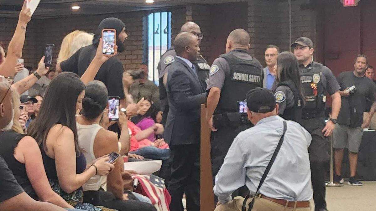 State Superintendent of Public Instruction Tony Thurmond is escorted out of the July 20 Chino Valley school board meeting by security officers. Board President Sonja Shaw said he went over the one-minute time limit for speakers.