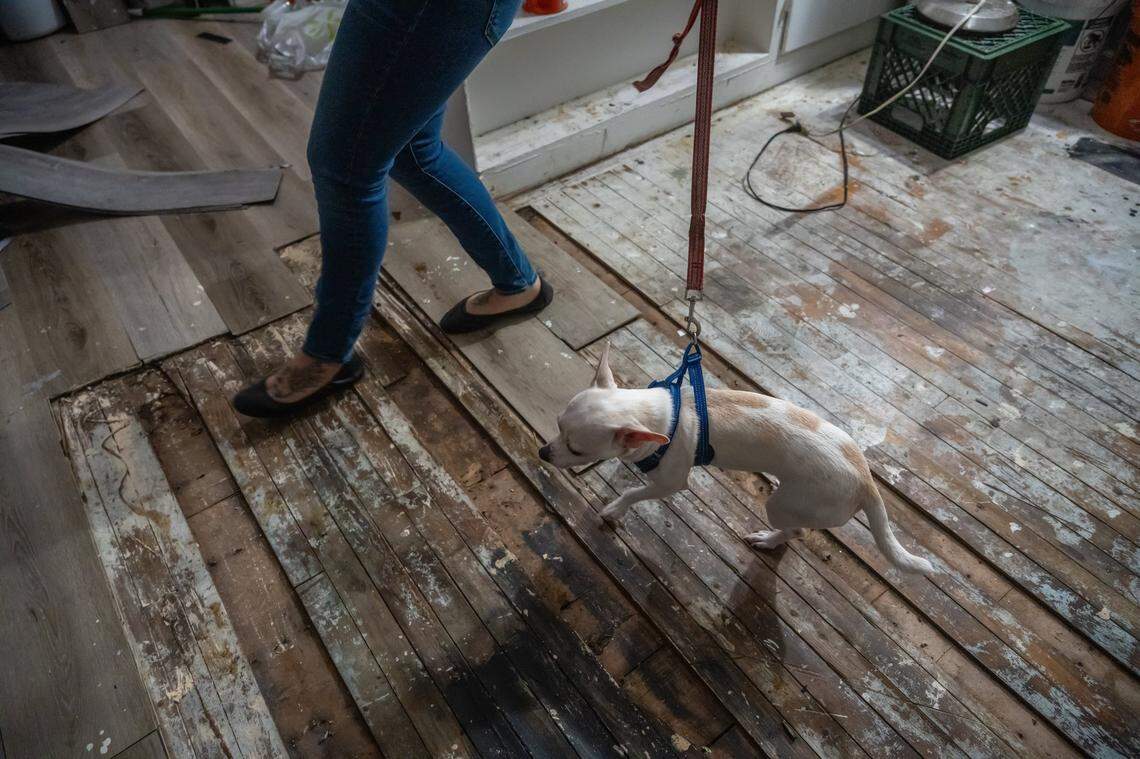 Corina Lovelace walks over old floorboards that have not been covered Oct. 25. She said you could see right down through them to the apartment below and worries about her safety.