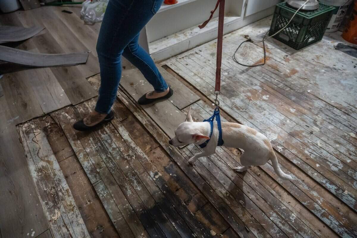 Corina Lovelace walks over old floorboards that have not been covered Oct. 25. She said you could see right down through them to the apartment below and worries about her safety.