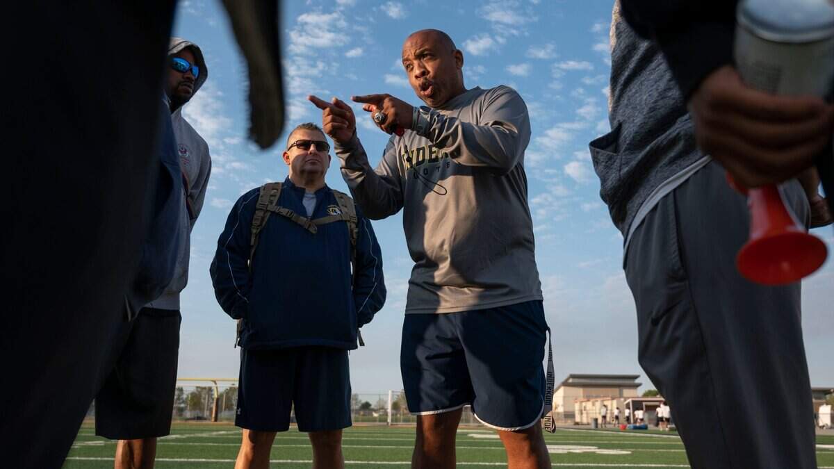 Inderkum High School head coach Reggie Harris talks to his assistant coaches after an early morning practice on Monday, July 25, 2022.