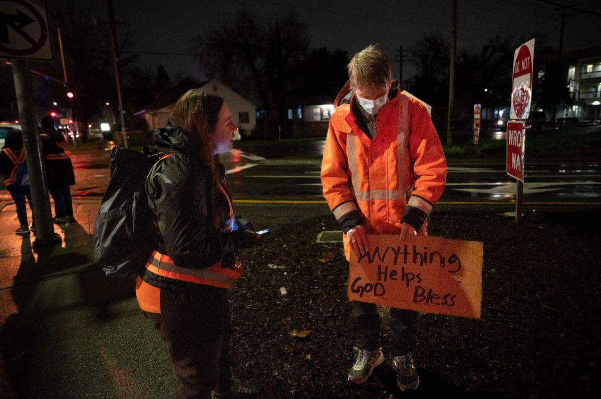 Rachael Austin, left, with the California Interagency Council on Homelessness and a volunteer with the 2024 Sacramento Regional Point in Time Count, talks with a homeless man near a freeway exit on H Street in the Marshall School neighborhood of Sacramento on Wednesday, Jan. 24, 2024. Over 800 volunteers canvassed the streets to determine how many people are living unhoused in the Sacramento region.  