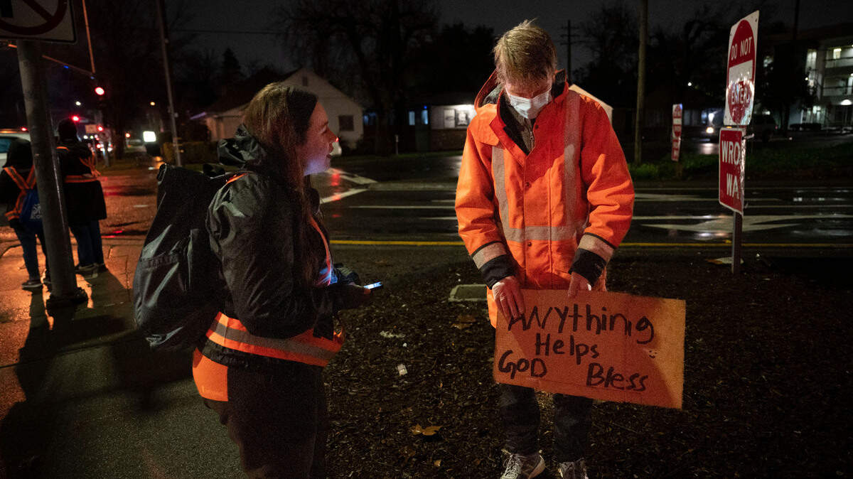 Rachael Austin, left, with the California Interagency Council on Homelessness and a volunteer with the 2024 Sacramento Regional Point in Time Count (PIT), talks with a homeless man near a freeway exit on H Street in the Marshall School neighborhood of Sacramento on Wednesday, January 24, 2024. PIT data shows that the number of unhoused people in the city and county – including those living in emergency shelters and other temporary housing – dropped by 28.7 percent, from 9,278 to 6,615.
