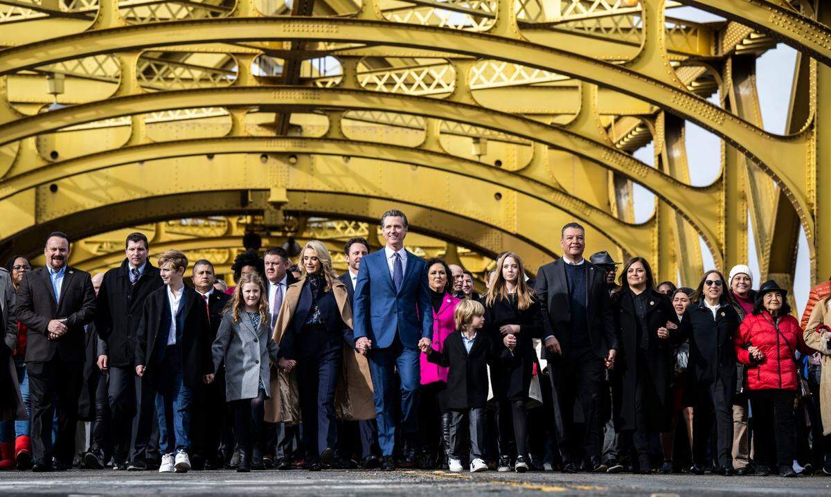California Gov. Gavin Newsom participates in a march from the Tower Bridge towards the statehouse for his inauguration Friday, with his family and various dignitaries and community members.