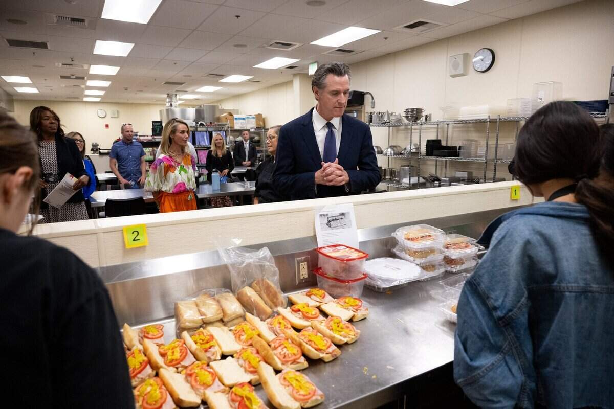 Gov. Gavin Newsom, alongside First Partner Jennifer Siebel Newsom, looks over food prepared by students in the Career Technical Education Pathways program at River City High School in West Sacramento on Thursday.