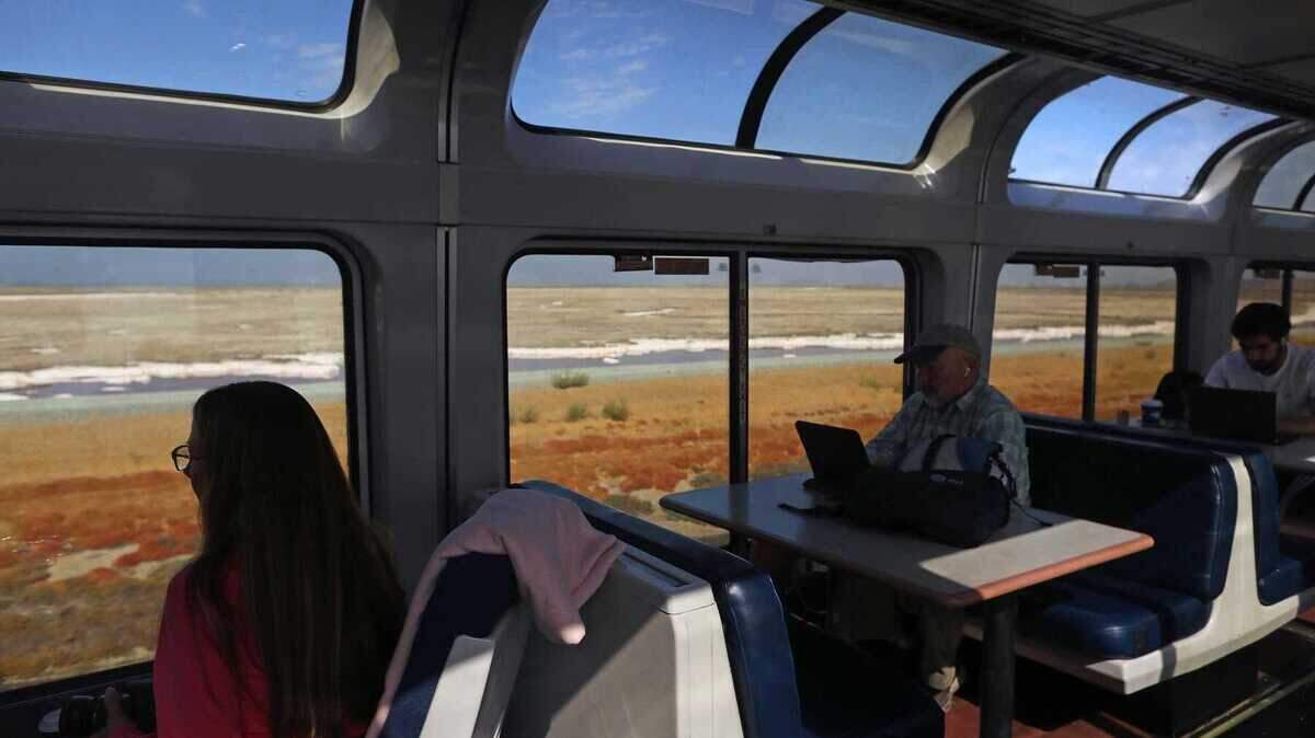 Passengers look out the windows of the viewing car of a bilevel Superliner train near Newark in South Bay. Amtrak plans to transition to single-level long-distance trains throughout its national network.