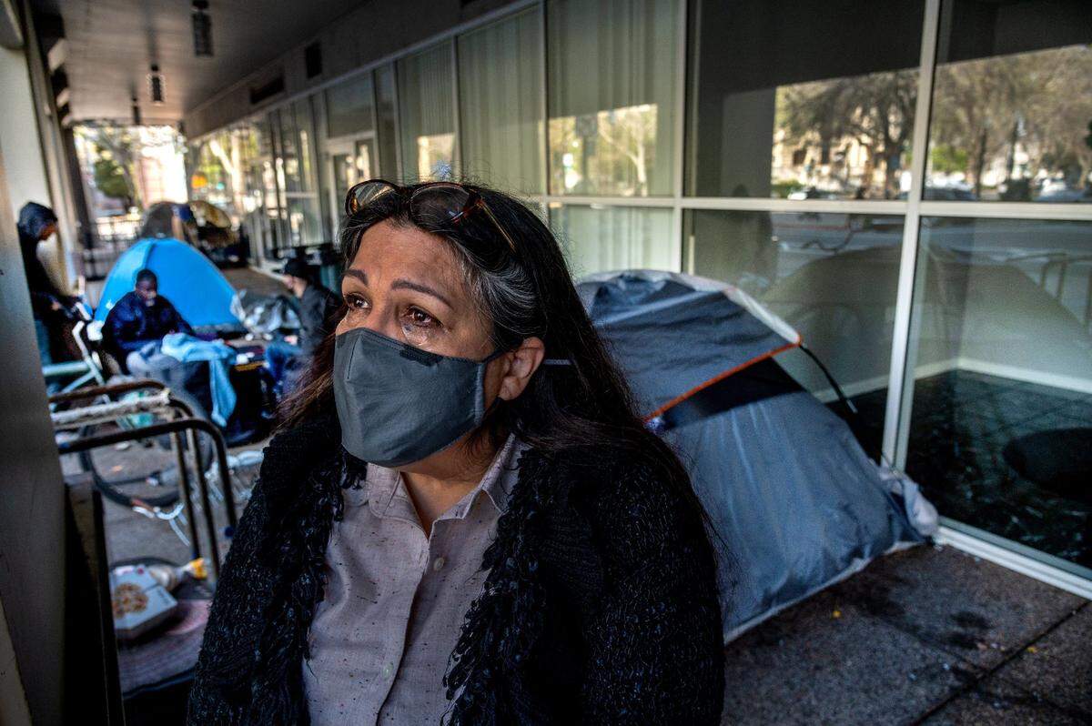 Tears stream down Alma Perez’s face as she waits for city officials to tell her the extent of damage to her salon Wednesday, March 24, 2021, after a van caught fire in the City Hall Garage, causing structure and smoke damage. The city had opened the garage to parking for homeless living in cars.