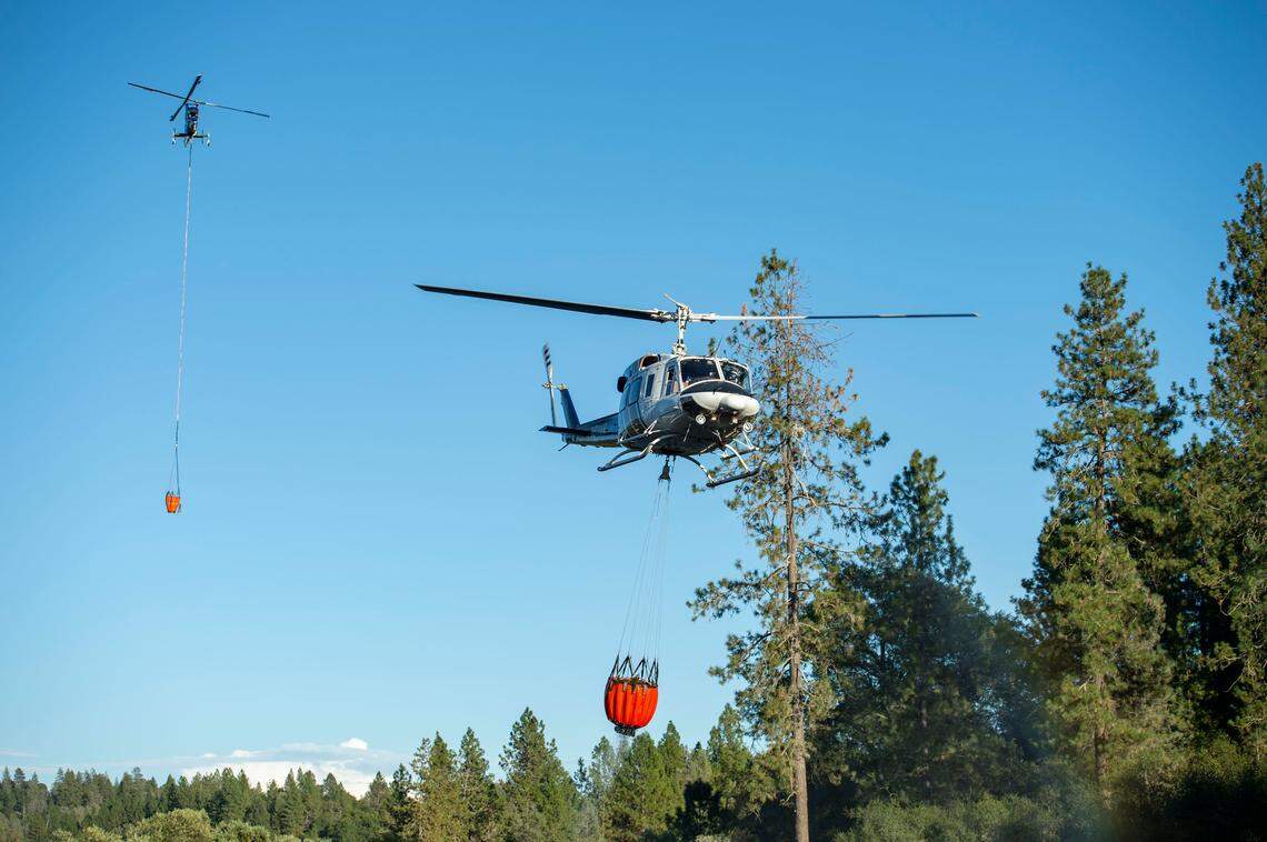 Two helicopters line up to refill with water from a local pond Tuesday, Sept. 3, 2019, as they fight the Country Fire in El Dorado County.