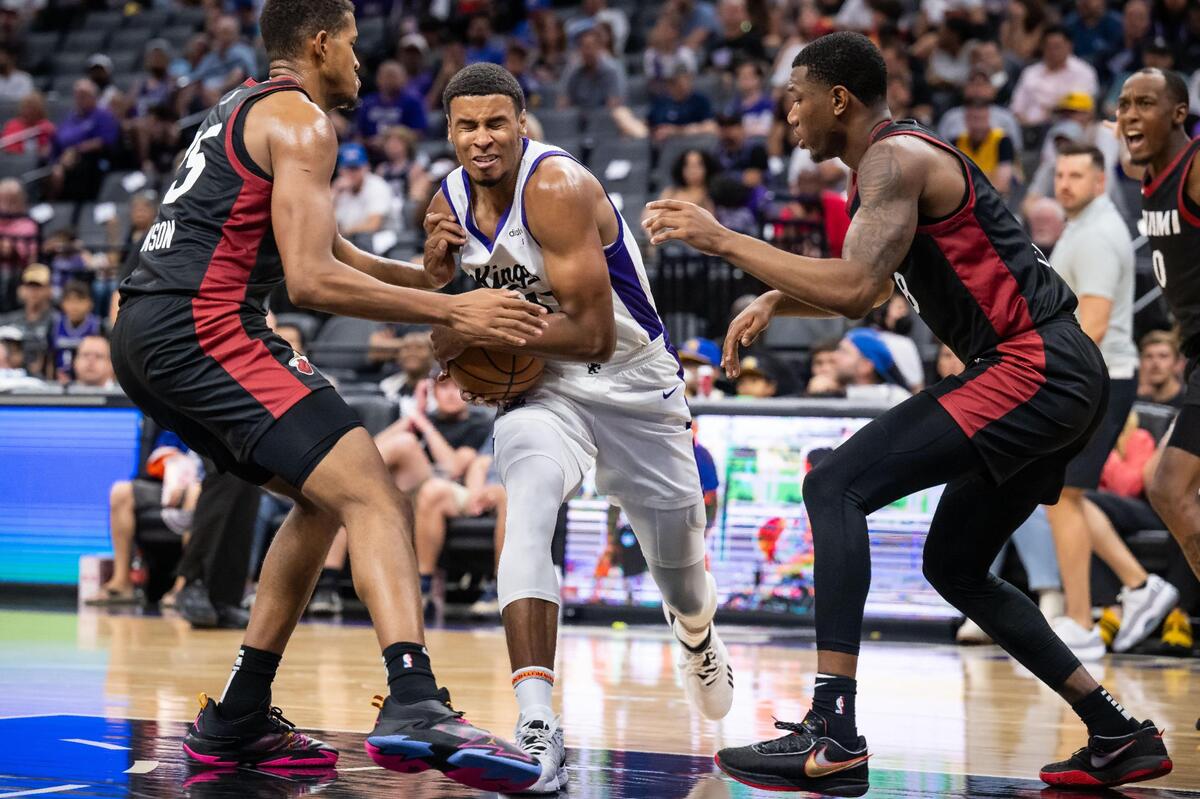 Sacramento Kings forward Keegan Murray (13), center, loses possession while trying to drive past Miami Heat center Orlando Robinson (25), left, and forward Jamal Cain (8), but recovers the ball and scores, during the second half of their California Classic NBA summer league basketball game Wednesday, July 5, 2023, at Golden 1 Center.