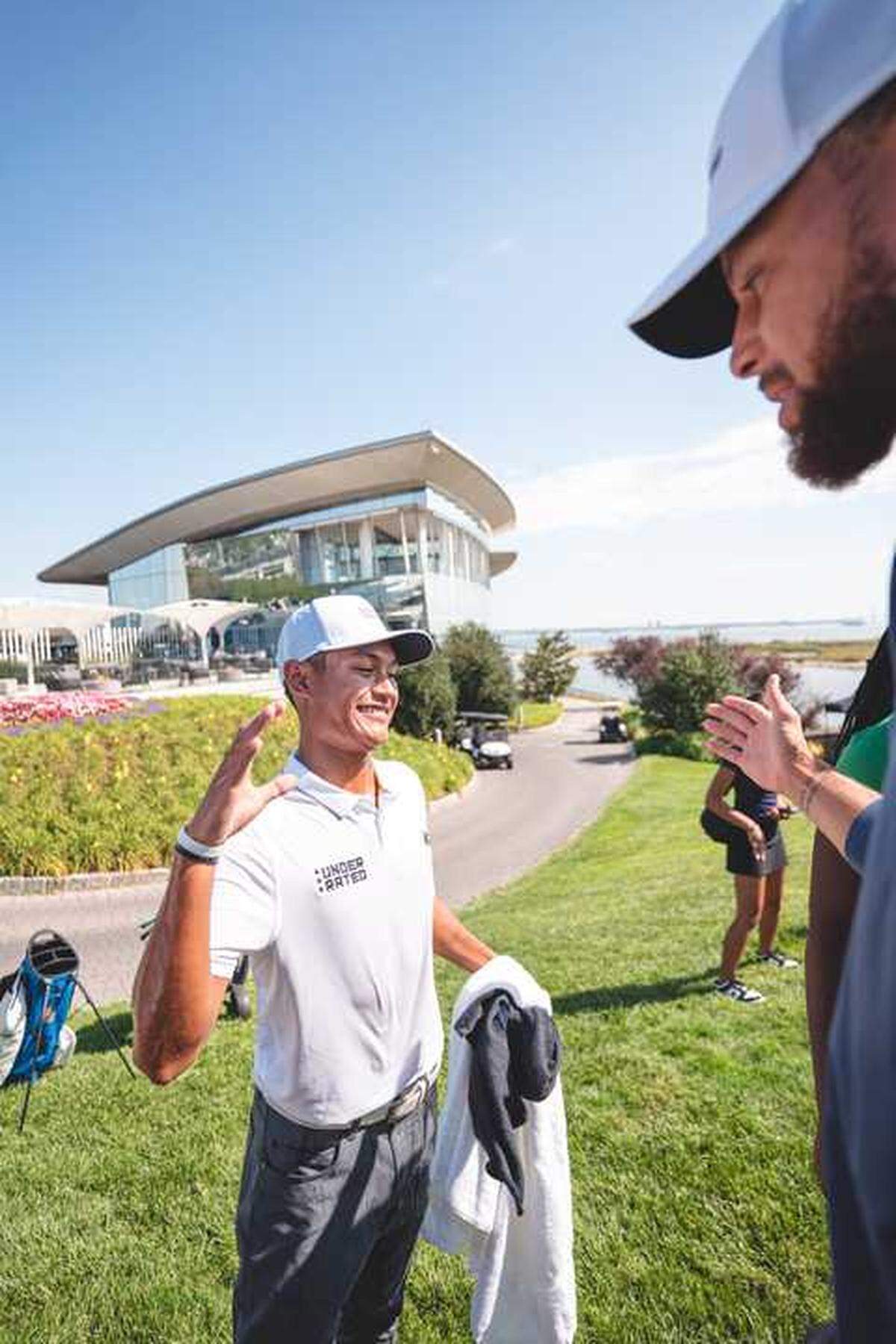 Jayden Lizama gets a high five from NBA star Steph Curry after winning the Curry Cup on Saturday, Sept. 13, 2025, at Liberty National Golf Club in Jersey City, N.J. Curry, who launched the Underrated Golf Tour in 2022 to expand access for young golfers from underrepresented communities, greeted players at the season-ending championship event.