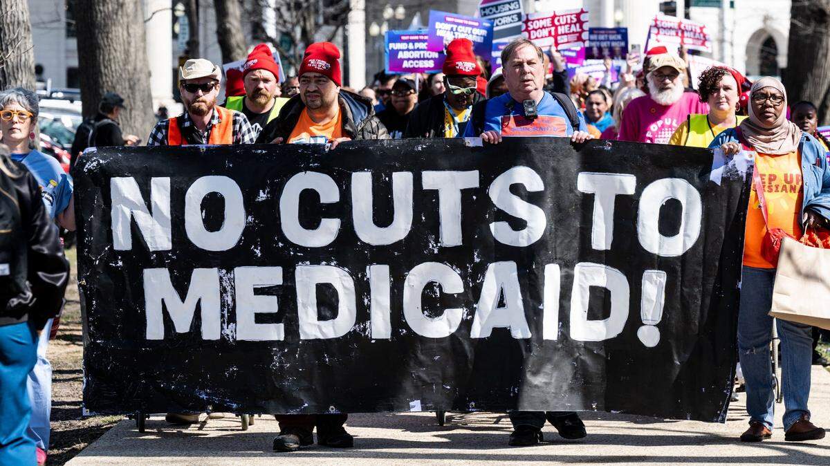 Protesters carry a banner saying “No cuts to Medicaid!” at a rally to save health care in Washington, D.C., in March.