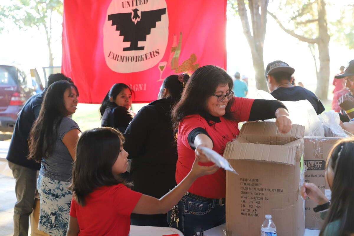La senora Veronica Mota, una miembra de la Union De Campesinos (UFW) repartindo mascarillas el 5 de noviembre en el Madera Sunrise Rotary Sports Complex.