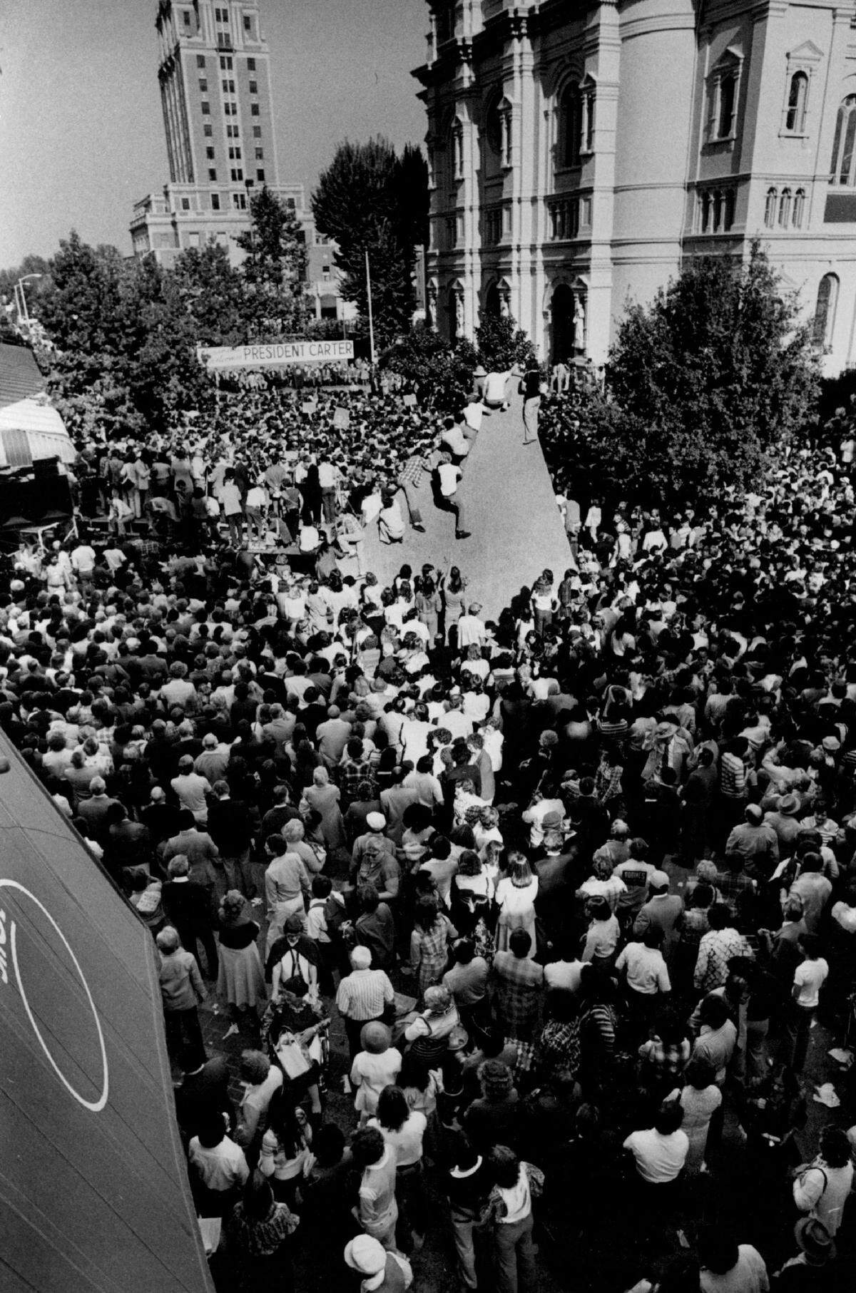 Supporters climb one of the concrete sculptures of the K Street pedestrian mall to get a better view of President Jimmy Carter speaking in front of the Cathedral of the Blessed Sacrament in November 1978.