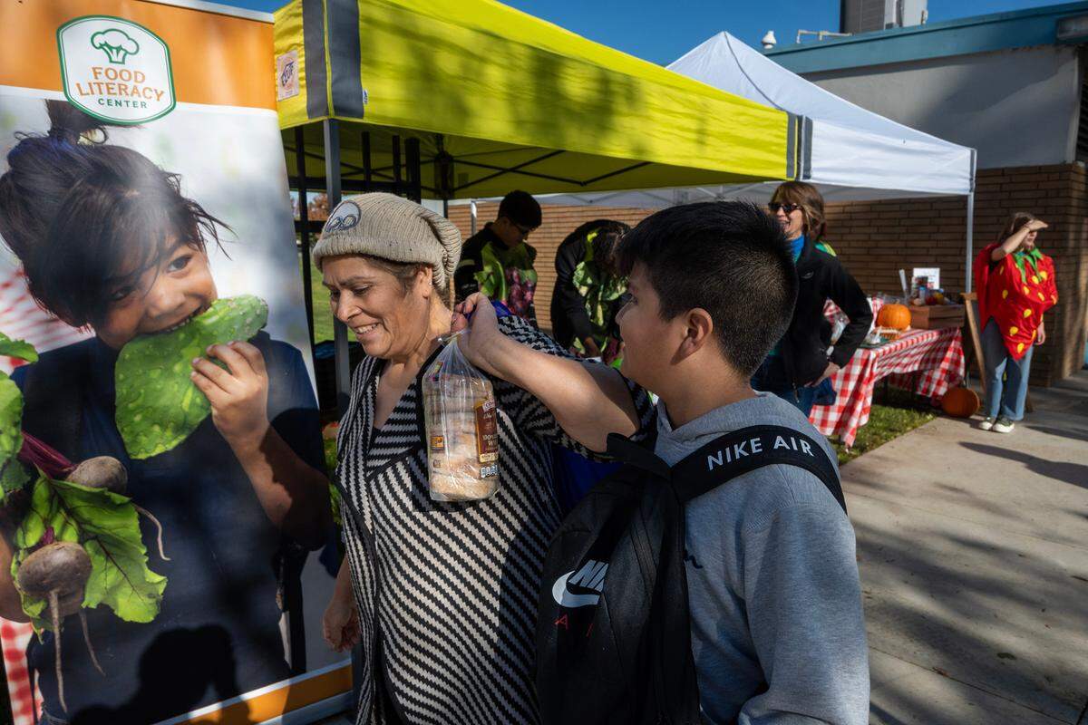 Mateo Gonzalez, 10, right, and his mother Raquel Gonzalez leave with a kit and bread they received from the Food Literacy Center Kitchen at John Sloat Elementary School earlier this month.