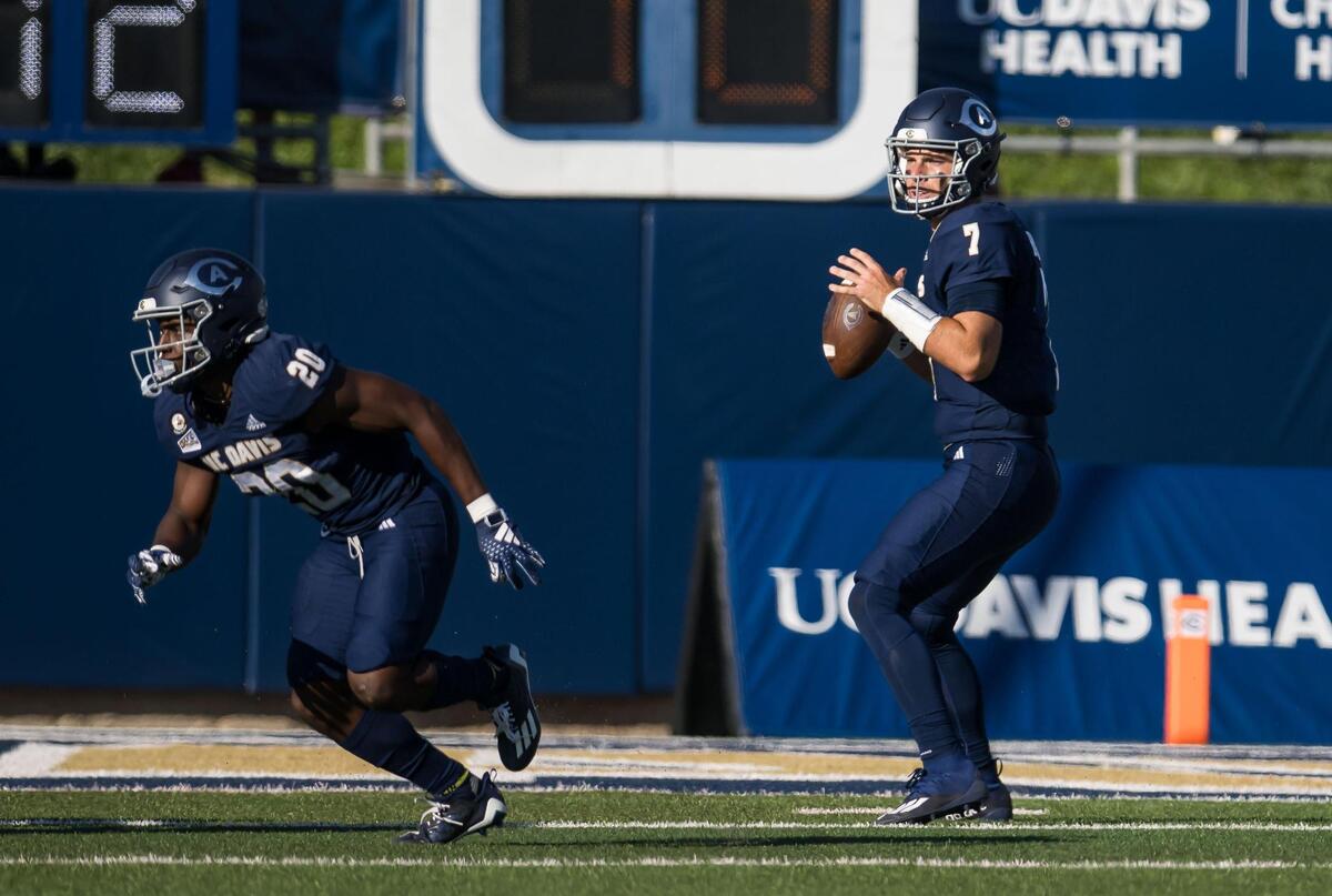 UC Davis Aggies quarterback Miles Hastings (7) looks for an open receiver, as running back Jordan Fisher (20) runs out at left, against the Montana Grizzlies during the first quarter of the NCAA college football game Saturday, Oct. 7, 2023, at UC Davis Health Stadium.