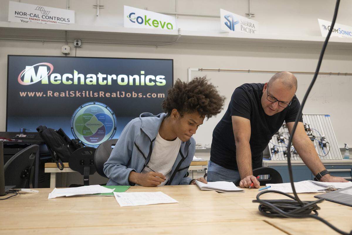 Sierra College professor Robert Fosselman, right, helps a student in the mechatronics lab at Sierra College in Rocklin earlier this month.
