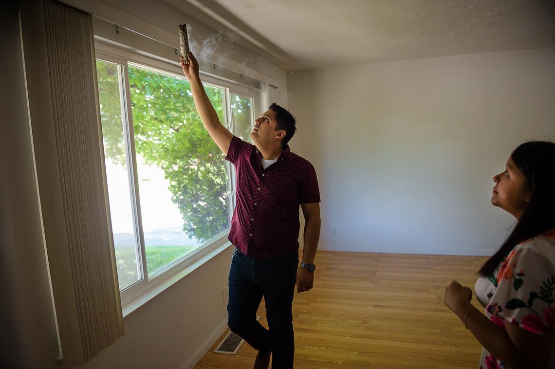 Andrew Llorente burns sage to purify their new home with his wife, Farrah Poladi, on Sunday, May 6, in Carmichael.