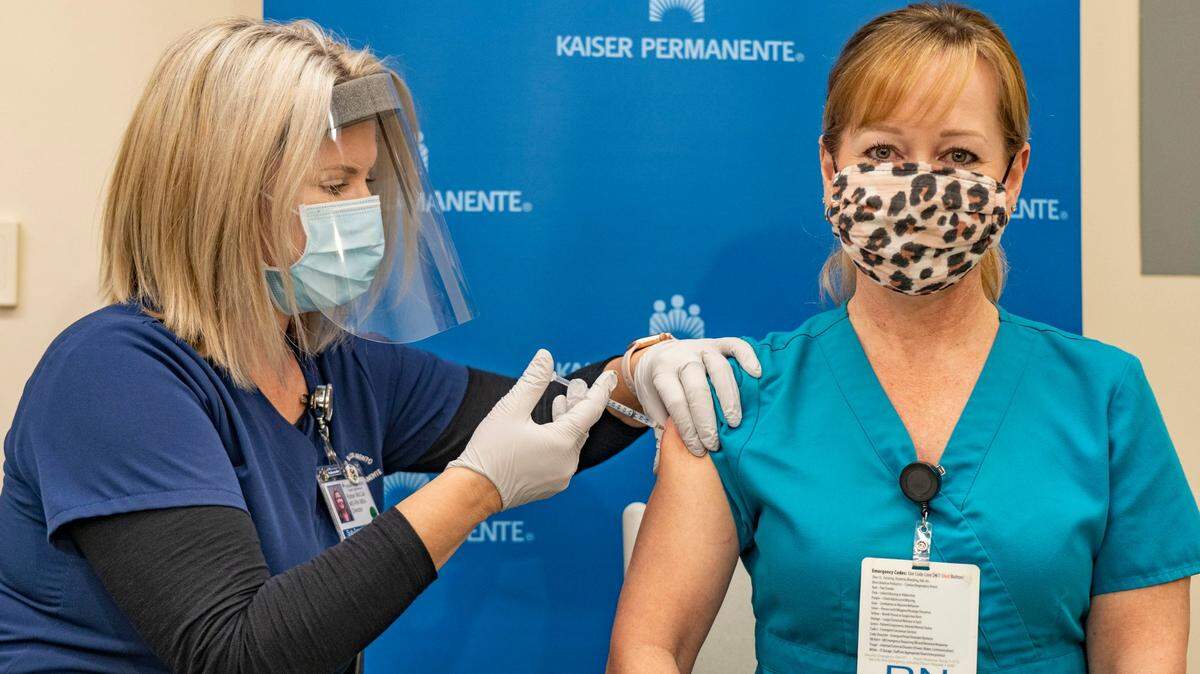 RN director Robyn McCall gives ICU nurse Heather Wright the first dose of Pfizer’s two-dose COVID-19 vaccine Friday, Dec. 18, 2020, at the Kaiser Permanente South Medical Campus in Sacramento.