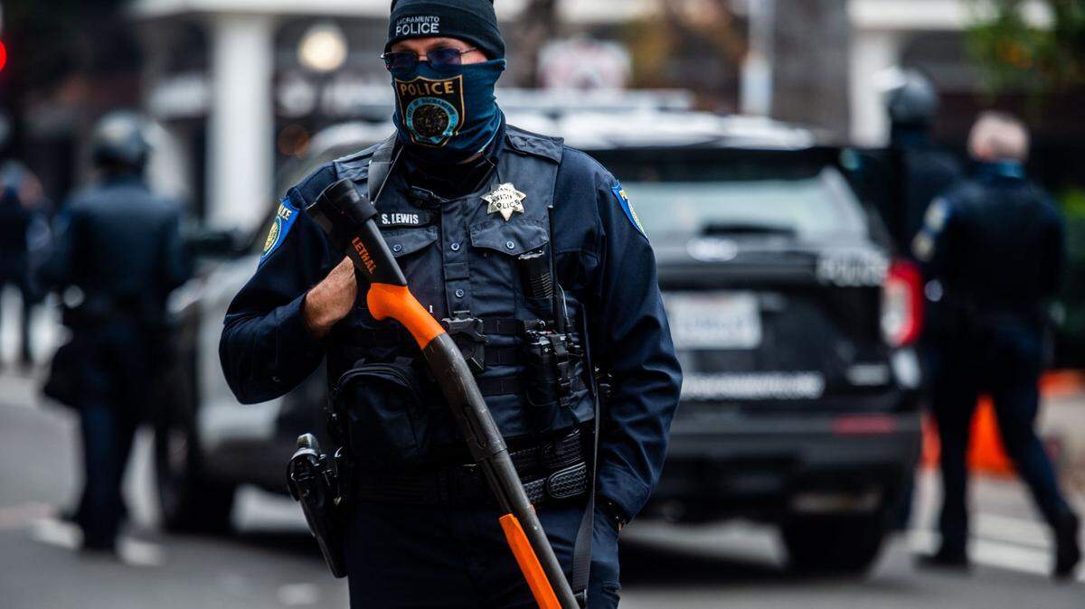 A Sacramento police officer holds a less lethal crowd control weapon at the state Capitol on Wednesday, Jan. 6, 2021, during a pro-Trump protest as a riot in Washington, D.C. delayed the certification of President-elect Joe Bidens victory. The Sacramento Police Department budget is expected to increase in the upcoming fiscal year.