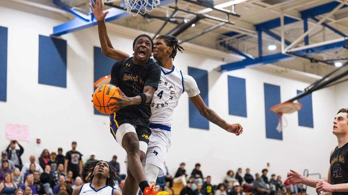 The Oakland Tech Bulldogs’ Ardarius Grayson (0) delivers a reverse layup as the Inderkum Tigers’ Taylen Goodman (4) defends during the second half of a CIF Northern California Division I quarterfinal in Sacramento on Thursday.