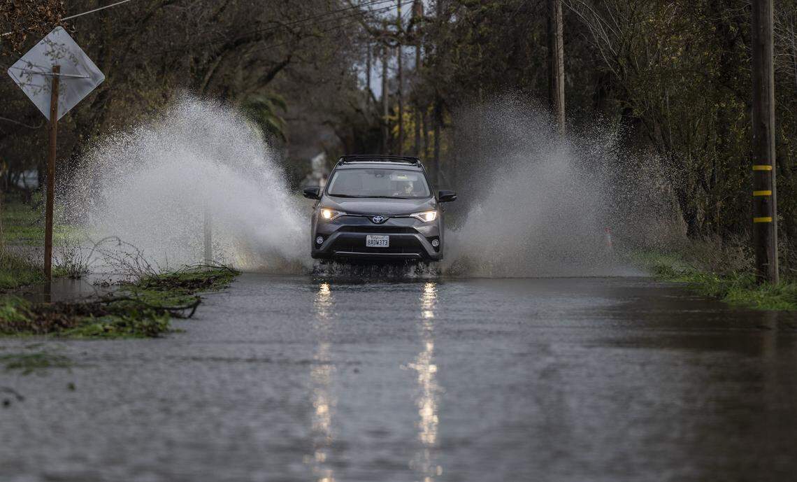 A motorist drives on the flooded Cherry Lane in Rio Linda on Friday, Dec. 26, 2025. Heavy rains on Christmas day brought flooding to the area from nearby Dry Creek.