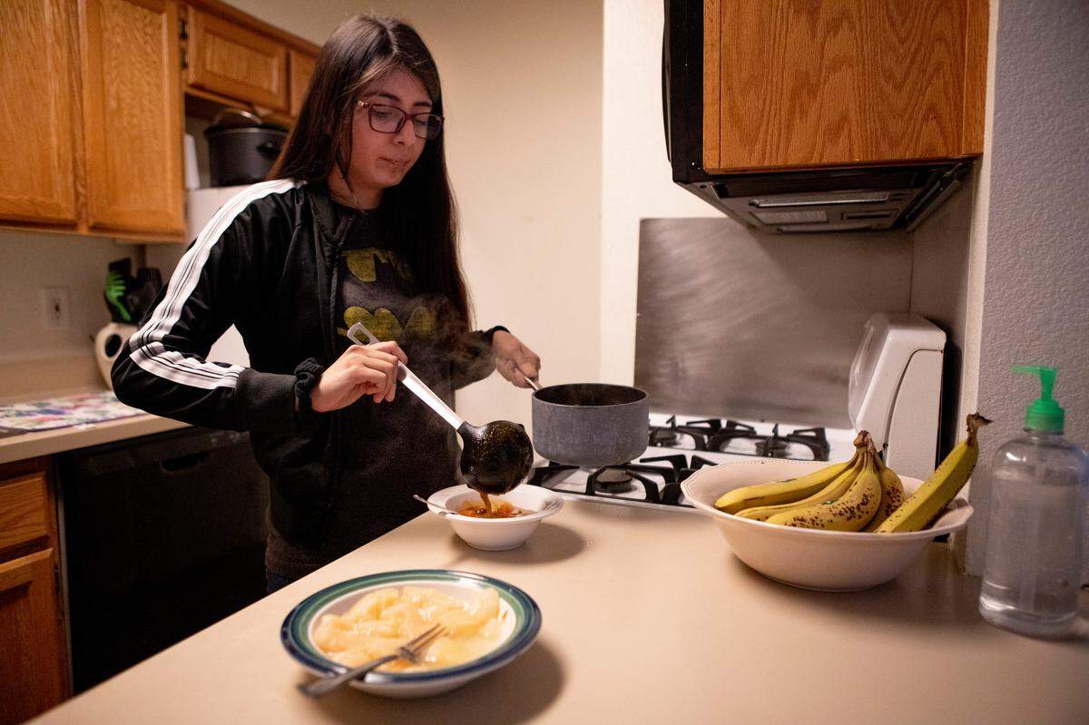 Beverly Callupe, 20, prepares lunch at the shelter after class. Some days, Callupe will skip lunch and wait until the shelter-provided dinner to save money.